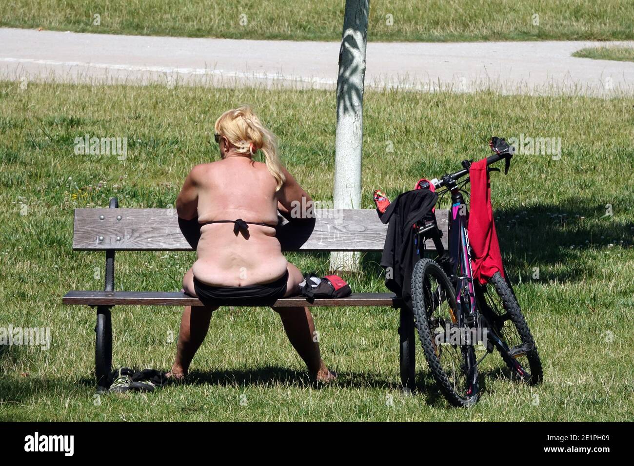Donna che prende il sole su una panchina nel parco cittadino Stromovka Praga Repubblica Ceca Foto Stock