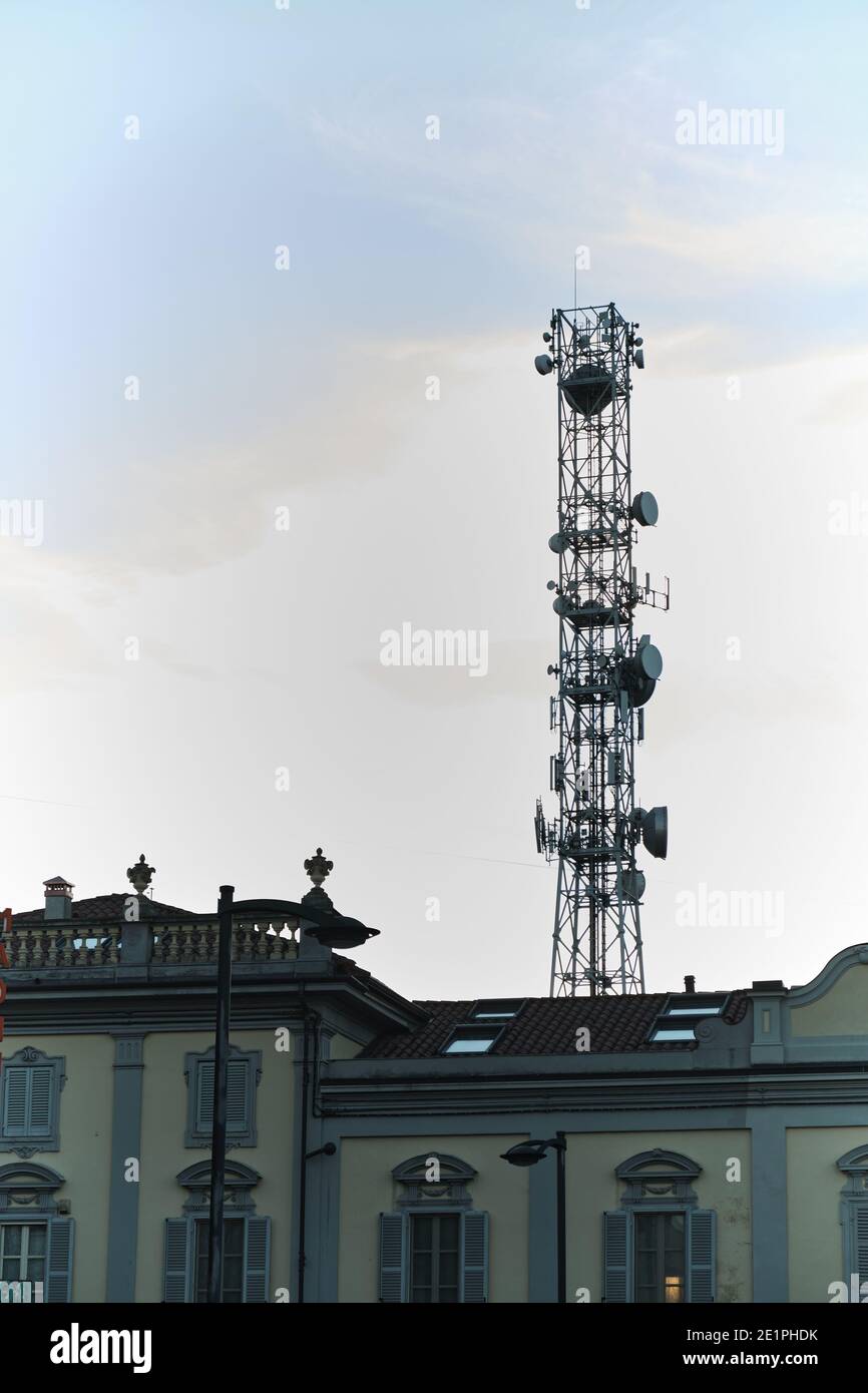 inquinamento elettromagnetico urbano: un'enorme antenna telefonica montata tra i tetti delle case Foto Stock