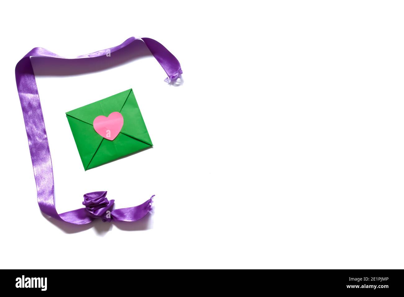 Busta verde e nastro viola isolato su sfondo bianco. Regalo di San Valentino. Concetto di San Valentino. Spazio per il testo. Foto Stock