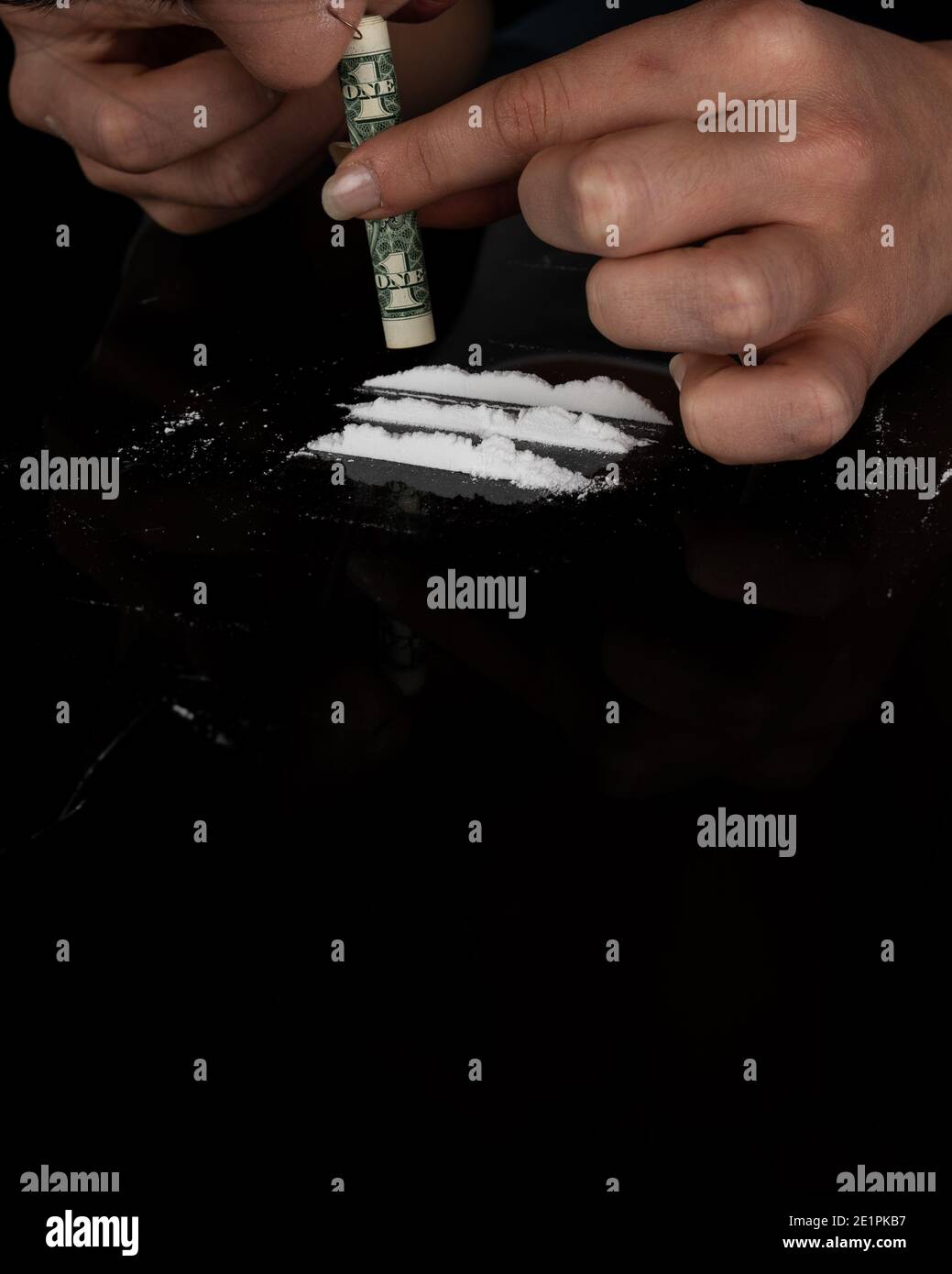 Donna tossicodipendente russare cocaina in polvere con banconota da dollaro arrotolata. Concetto di stupefacenti. Primo piano della macro. Shot verticale. ph acuto ad alta risoluzione Foto Stock