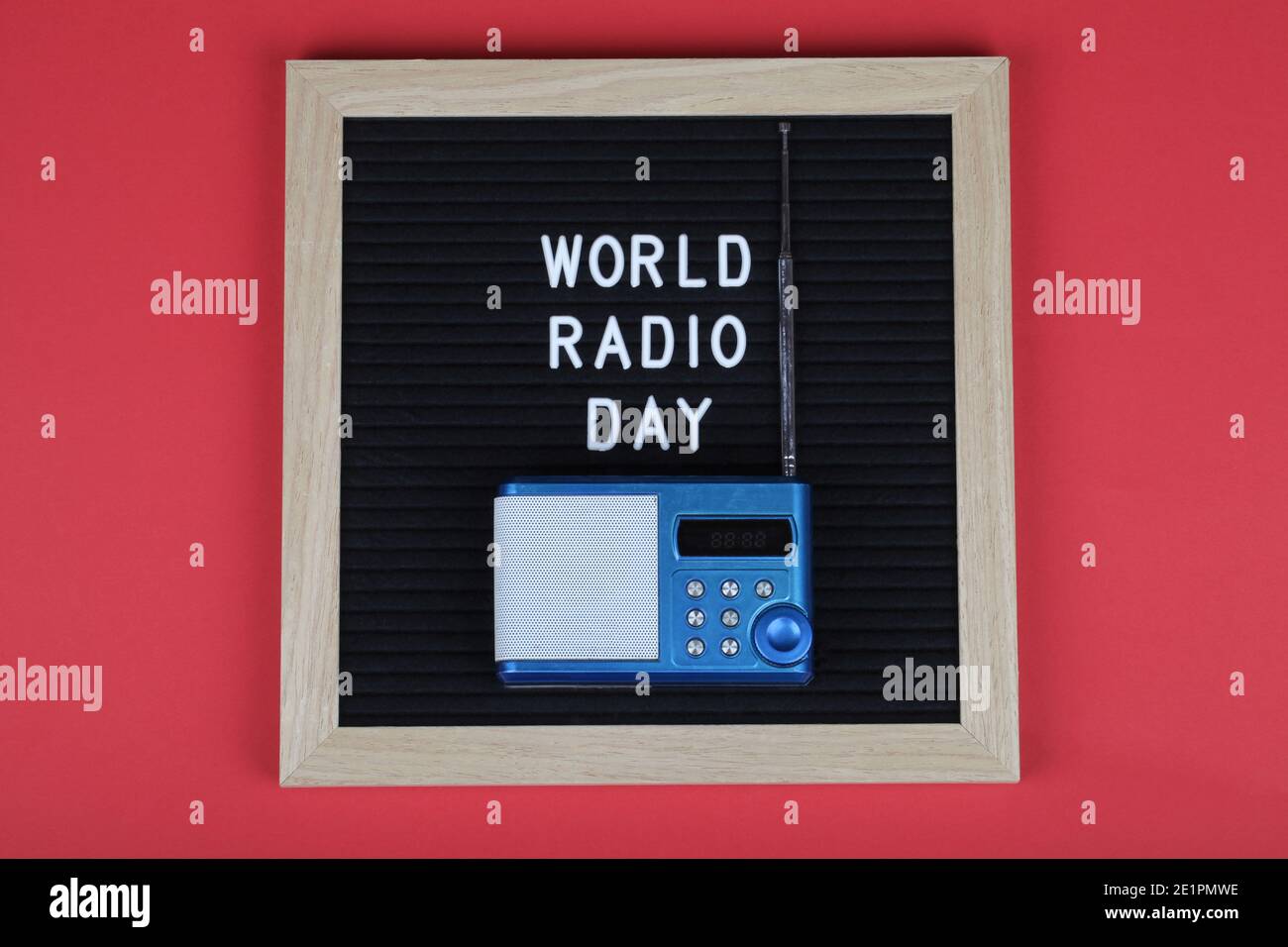 lavagna nera con testo mondo radio giorno con radio blu su sfondo rosso. Vista dall'alto. Disposizione piatta sfondo minimo. Foto Stock