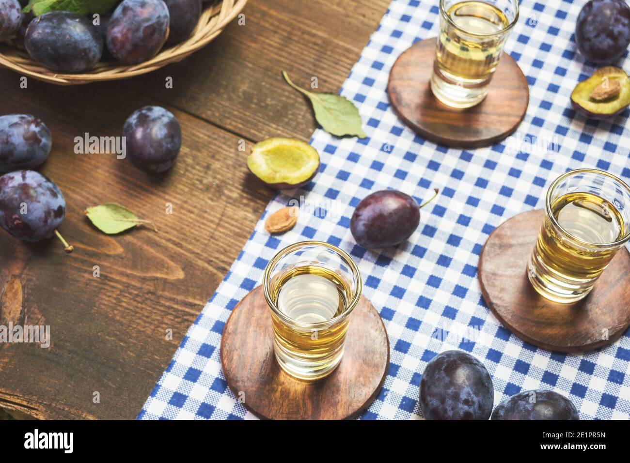 Rakija, raki o rakia è un tipo di brandy di bevanda alcolica forte balcanica a base di frutta fermentata. Rachia di prugne su tavola rustica di legno. Foto Stock
