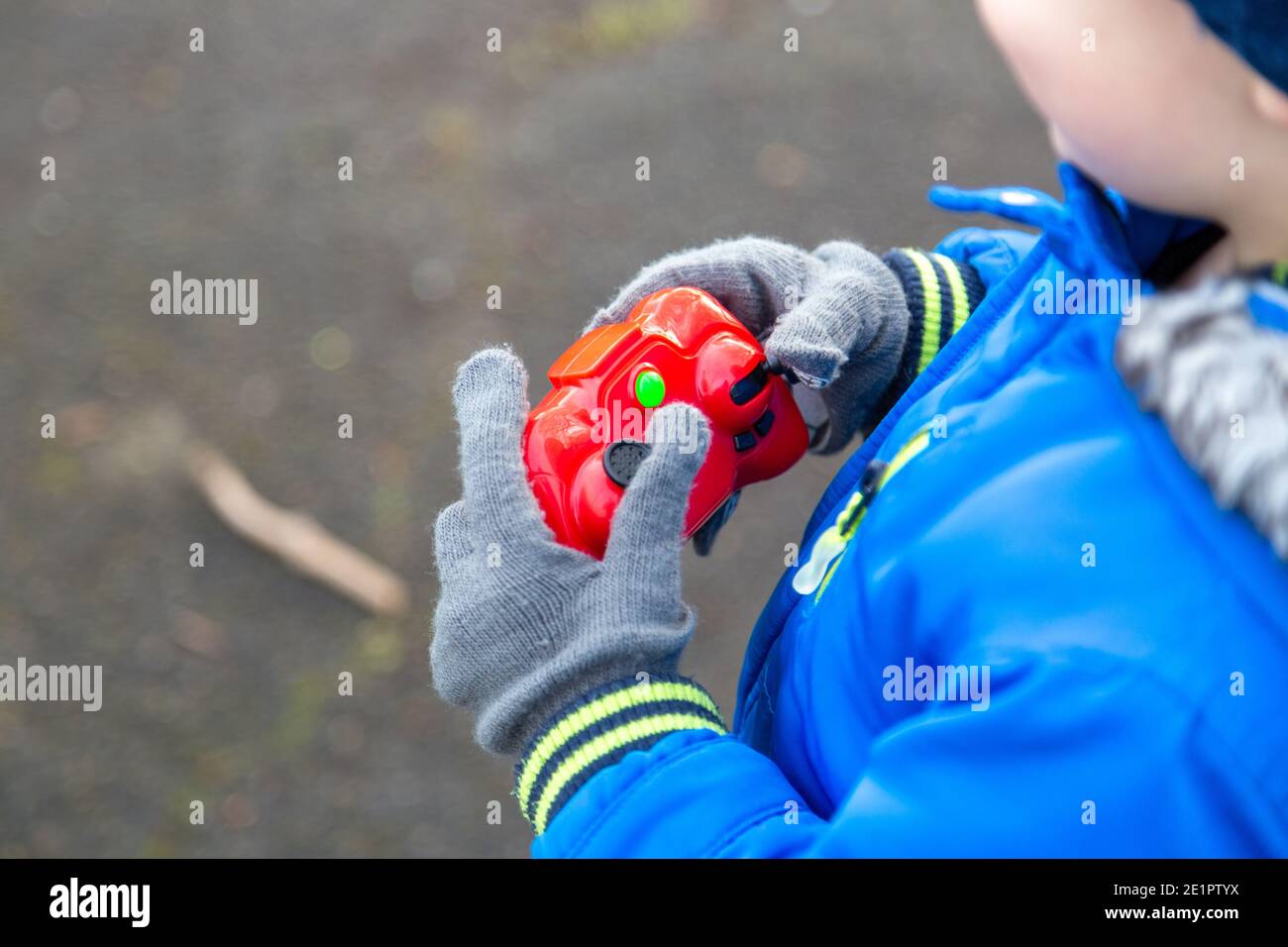 Un bambino che regge il controllo di un'auto con telecomando esterno Foto Stock