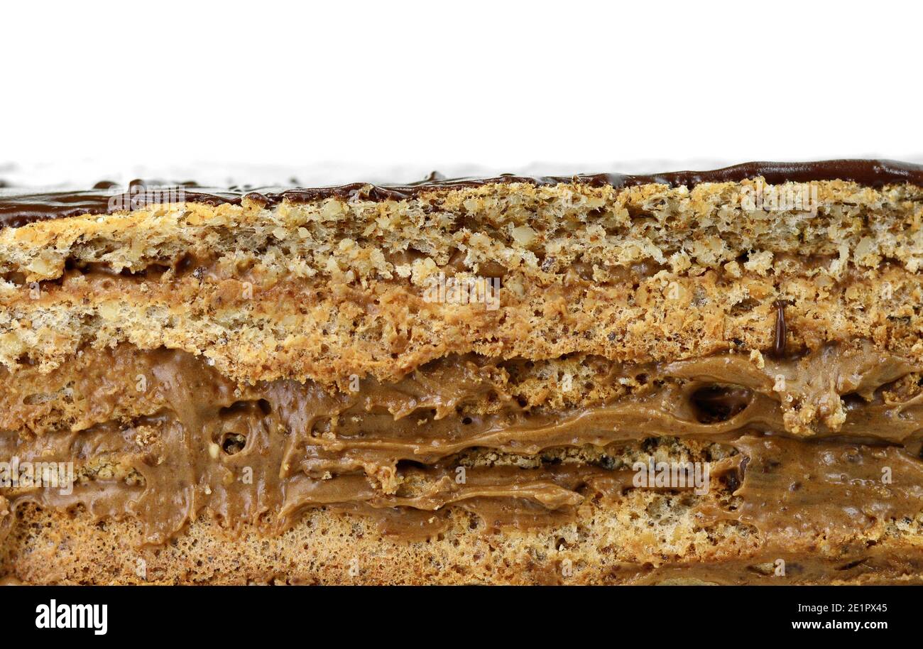 Torta con strati di cioccolato e crema al caramello. Isolato su sfondo bianco. Sezione di torta al cioccolato multistrato con smalto al cioccolato. Foto Stock