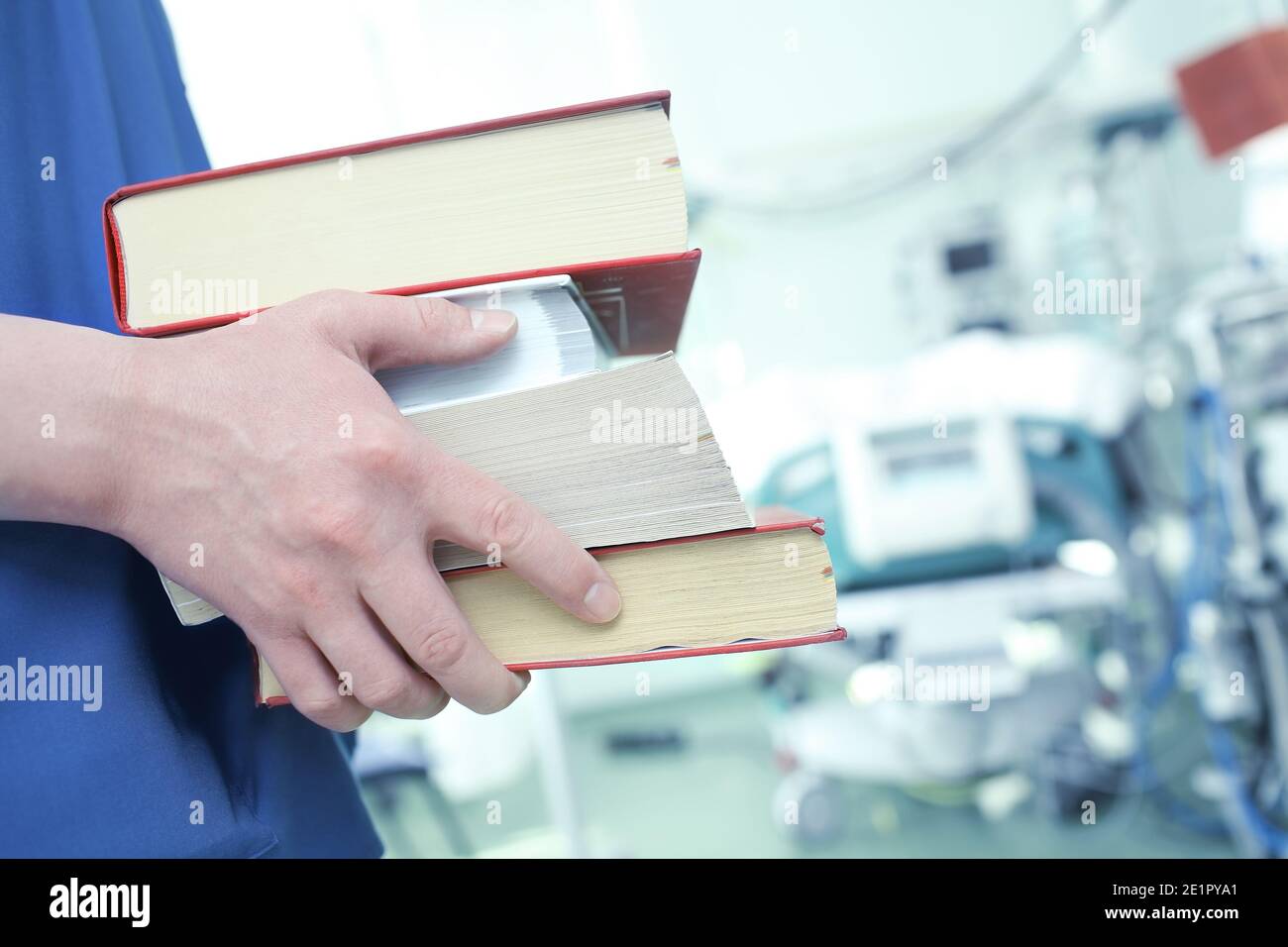 Medico maschile con libri in ICU. Foto Stock