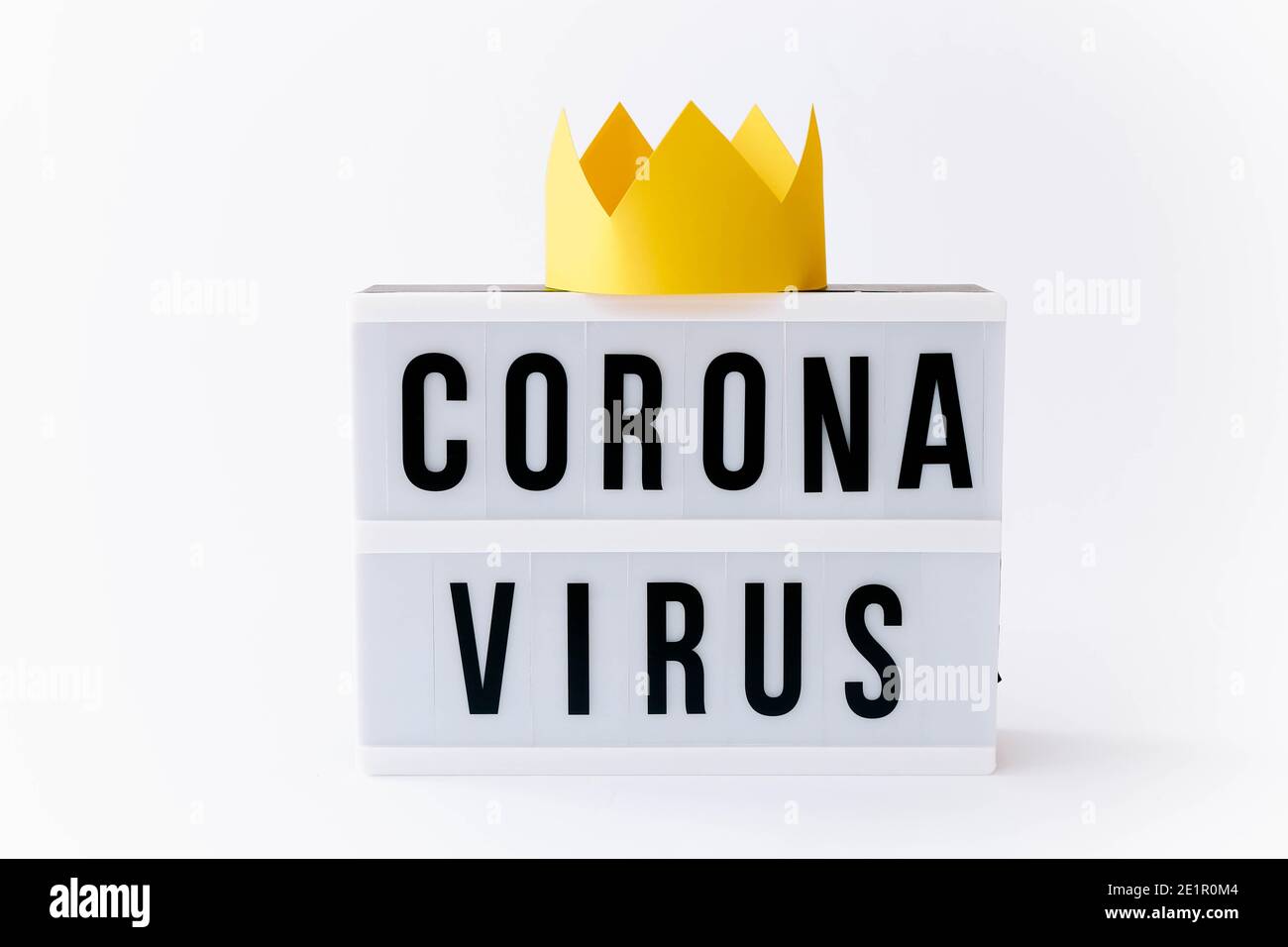 Covid 19, Corona virus testo in mostra in lightbox con corona su di esso, sfondo chiaro. Foto Stock