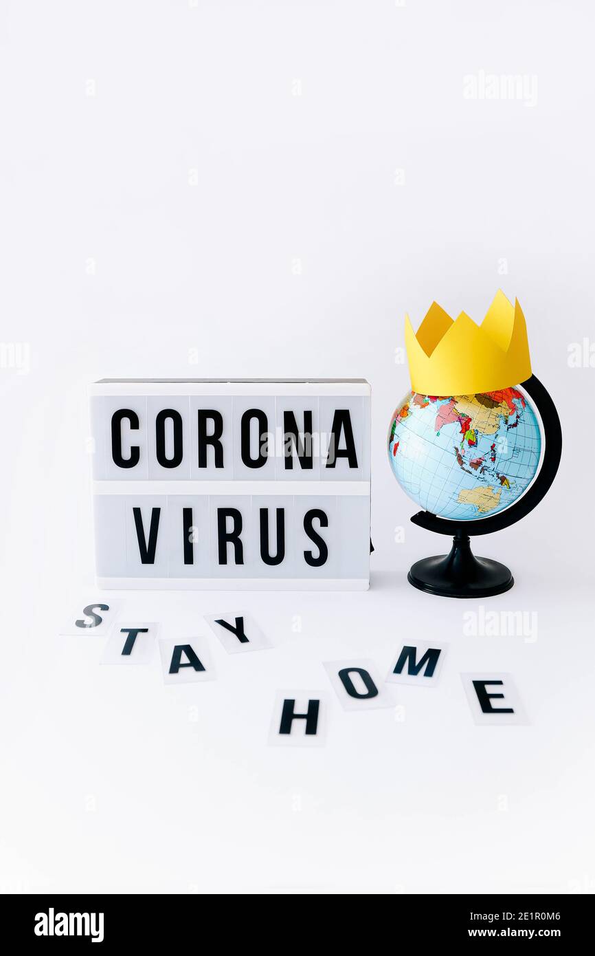 Concetto di Covid 19, Corona virus testo in mostra in lightbox e globo con corona su di esso, sfondo chiaro. Foto Stock