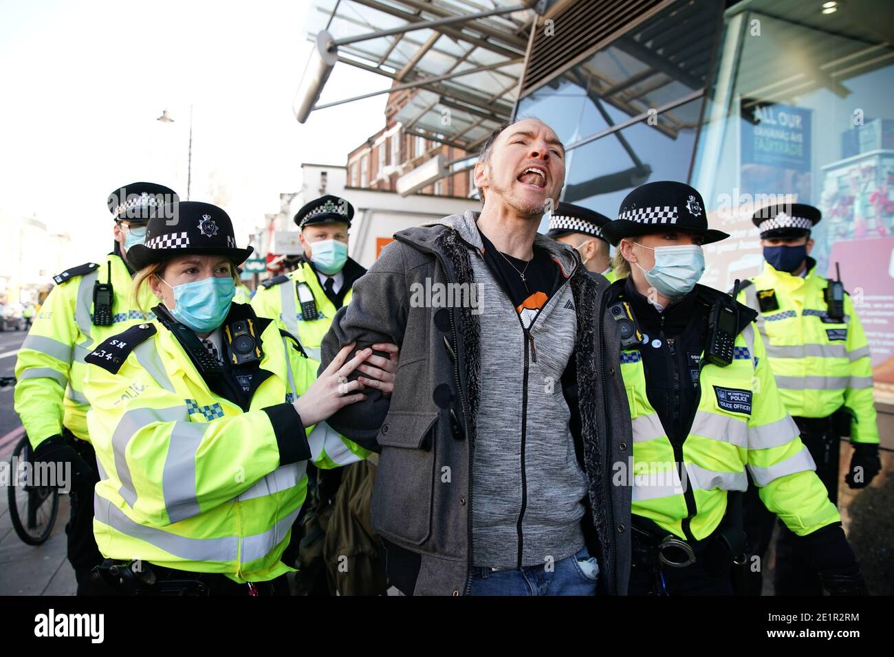 La polizia detenere un uomo durante una protesta anti-blocco a Clapham Common, Londra. Foto Stock