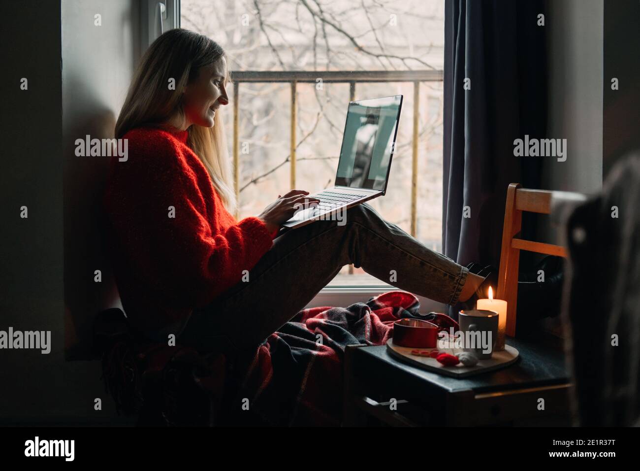 Donna che usa l'app online dating sul laptop. Giorno di San Valentino durante l'epidemia di Coronavirus. Amore a distanza, solitudine in auto-isolamento nel tempo di Foto Stock