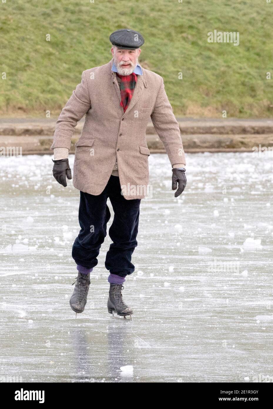 Un uomo pattina sul laghetto ghiacciato di Inverleith Park, Edimburgo. Foto Stock