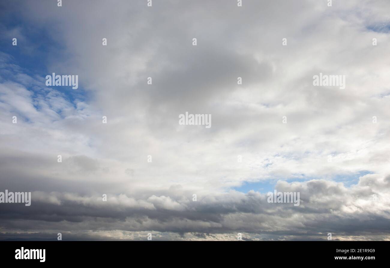 Vista del cielo con nuvole bianche che diventano più scure all'orizzonte. Foto Stock