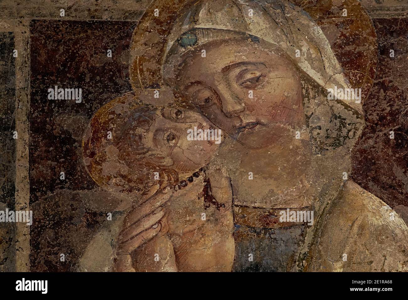 Vergine e Cristo bambino. Affresco tardo medioevale, probabilmente dipinto nel 1300 da un pittore di scuola senese, nella Chiesa di Sant'Alessandro a Volterra, in Toscana. Foto Stock