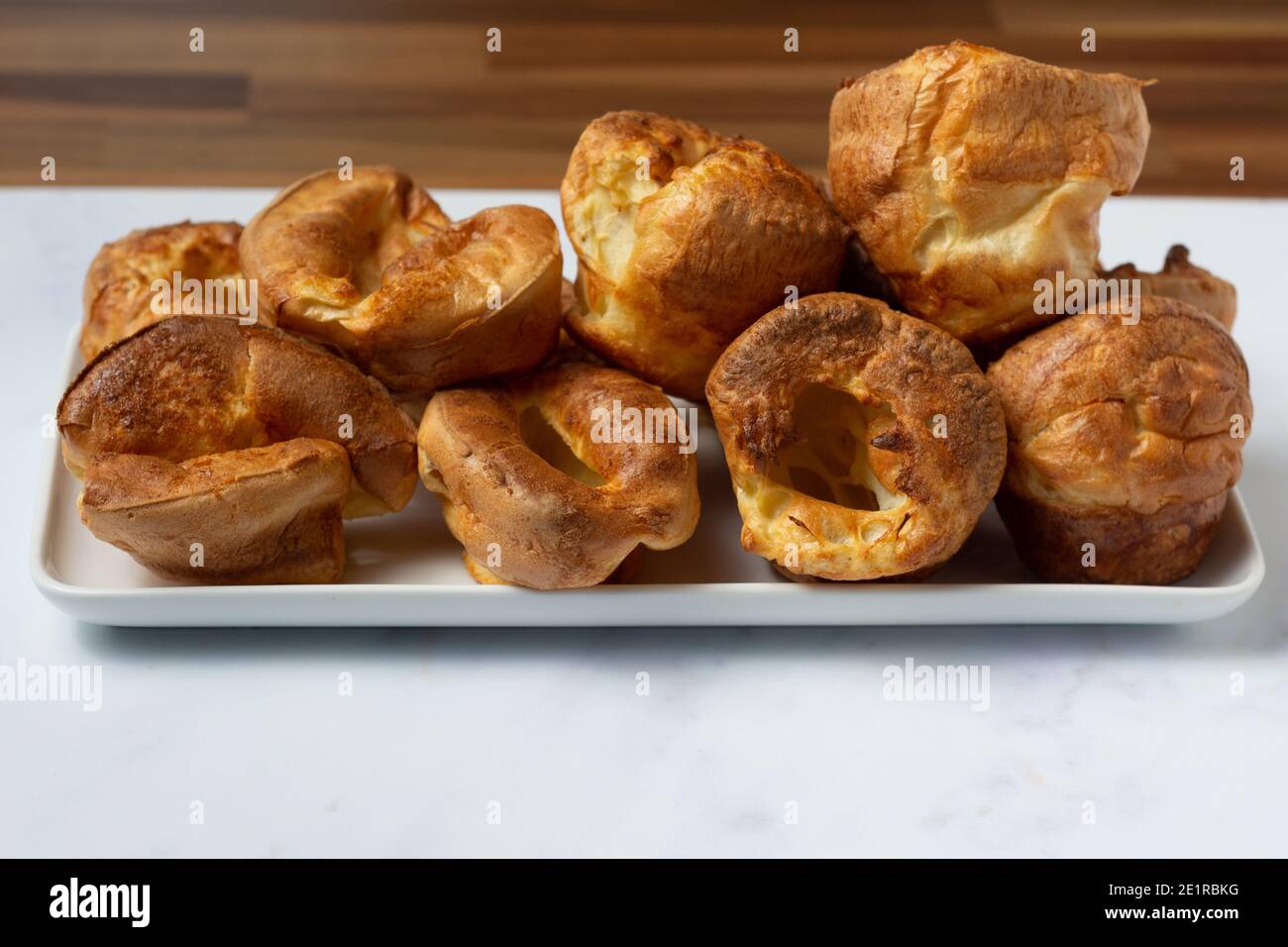 Yorkshire pudings visto dal lato accatastato su un bianco vassoio Foto Stock