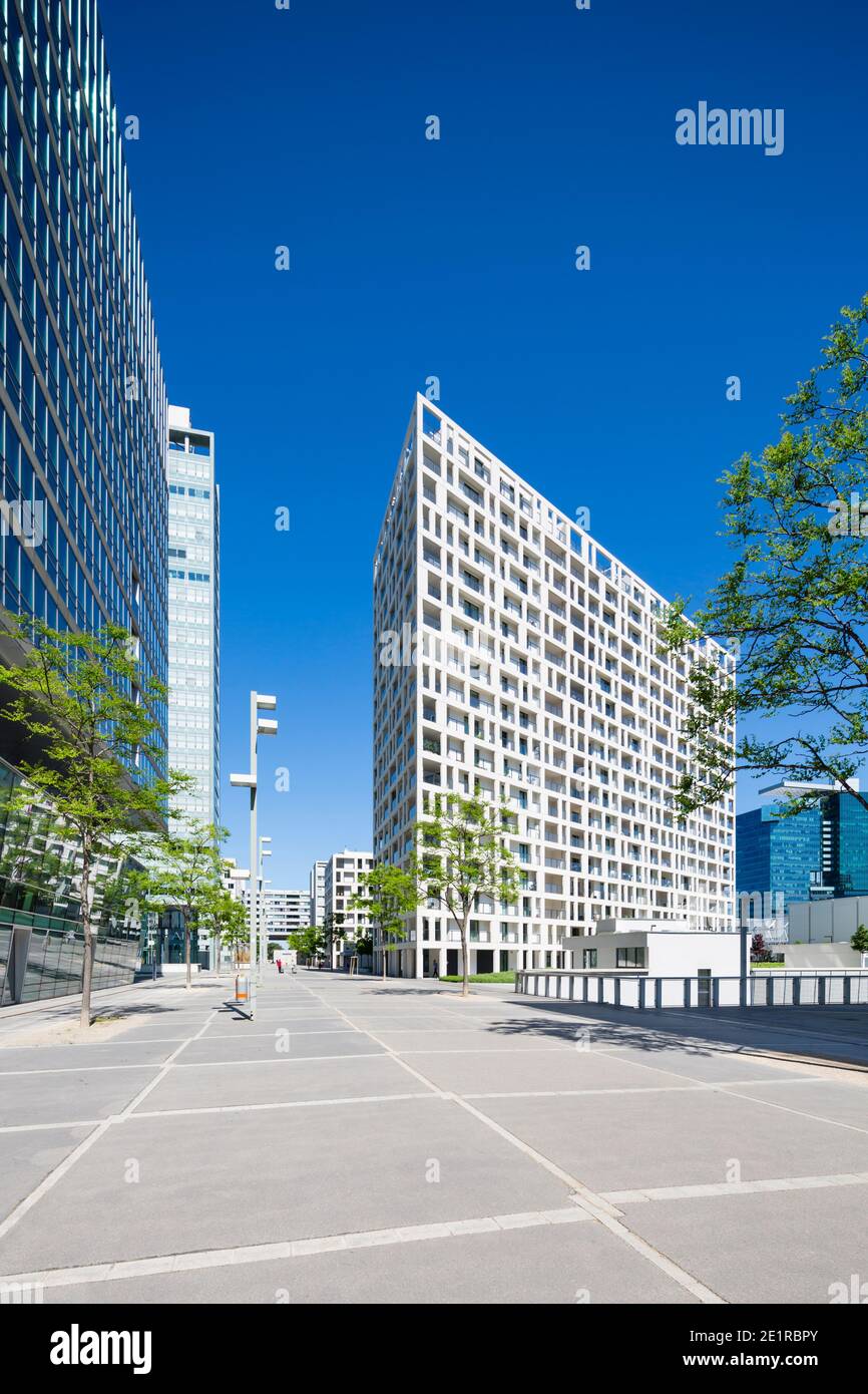 Il moderno edificio degli appartamenti DC Living si trova nella Donau City Street di Vienna, in Austria, con il cielo blu e la prospettiva diritta. Foto Stock