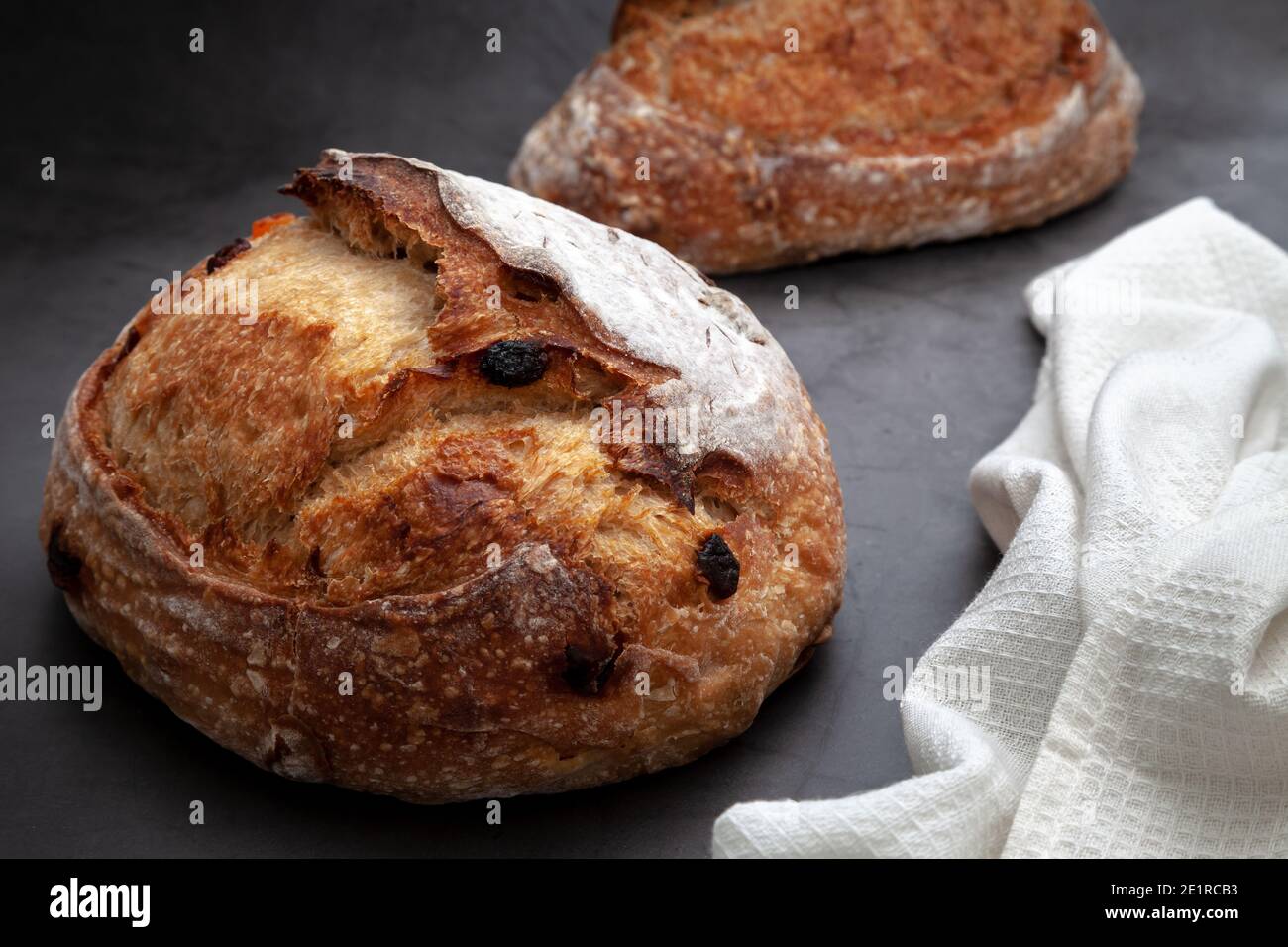 Pane sourpaste con frutta mista e noci su fondo di cemento scuro. Foto Stock