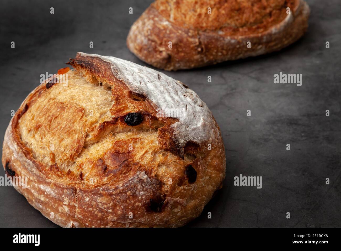 Pane sourpaste con frutta mista e noci su fondo di cemento scuro. Foto Stock