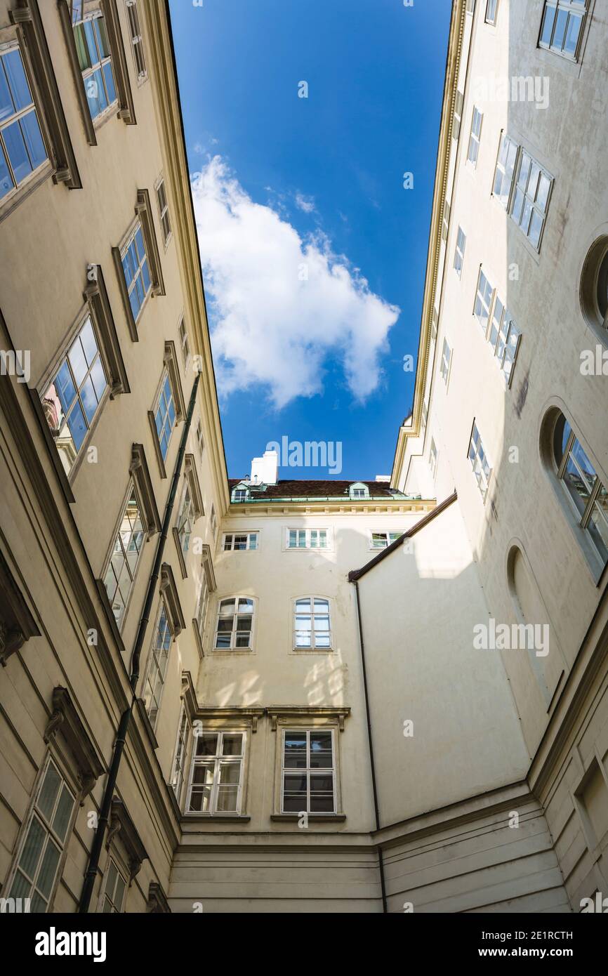 Edifici intorno a uno dei cortili interni stretti dell'Hofburg a Vienna, Austria con cielo blu. Foto Stock