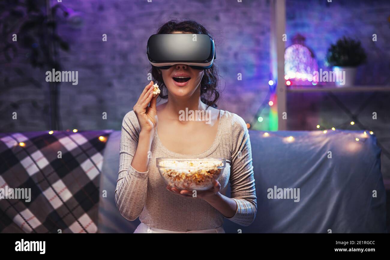 La giovane ragazza che ottiene il visore VR di esperienza sta usando gli  occhiali di realtà aumentata che sono nella realtà virtuale. Giovane donna  indossa il visore VR e guarda il film