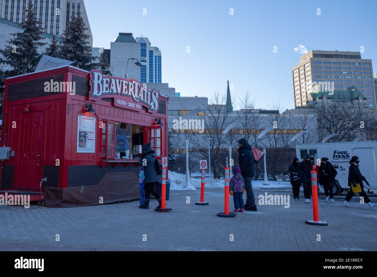 Ottawa, Ontario, Canada - 8 gennaio 2021: I clienti aspettano in una linea a distanza fisica presso uno stand di pasticceria BeaverTails presso il municipio di Ottawa. Foto Stock