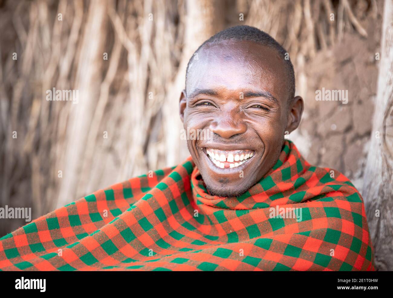 Il giovane guaritore di Datoga sorride e si agghiacciava fuori casa Foto Stock
