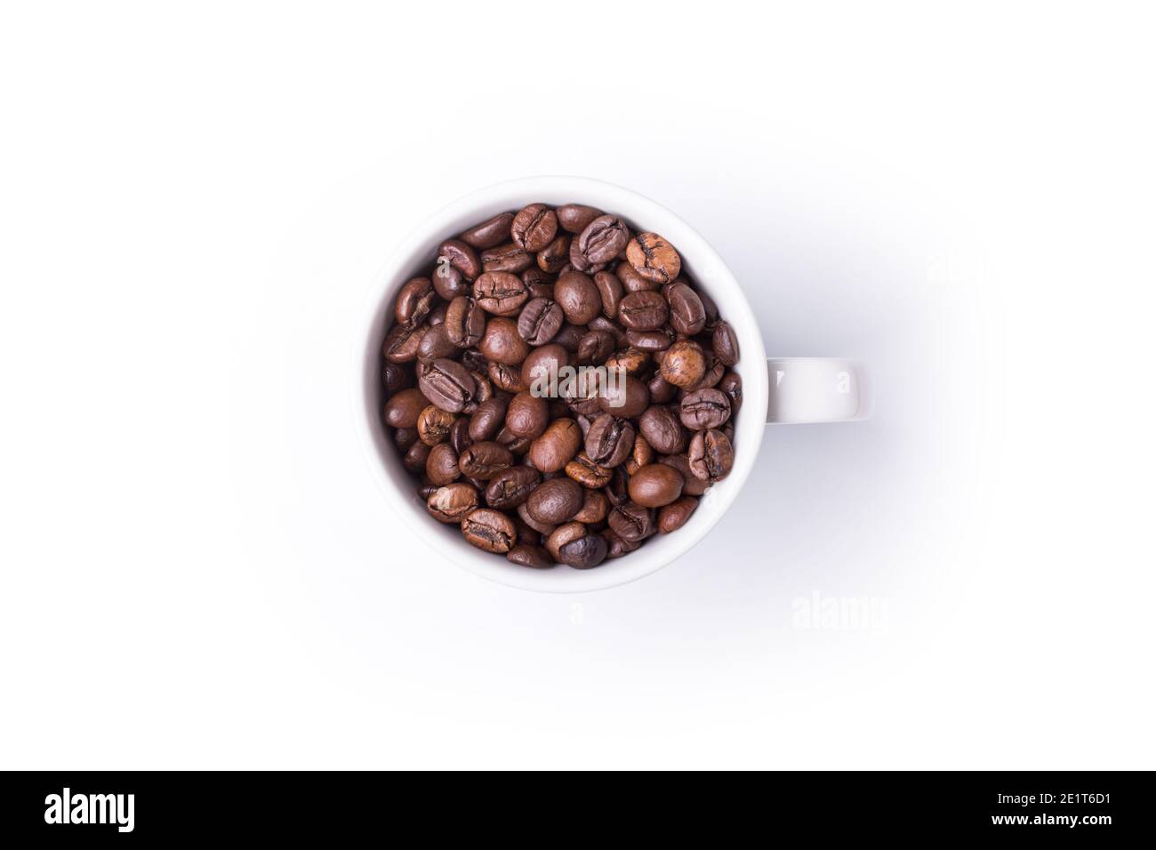 Vista dall'alto della tazza bianca con caffè appena tostato fagioli isolati su sfondo bianco Foto Stock