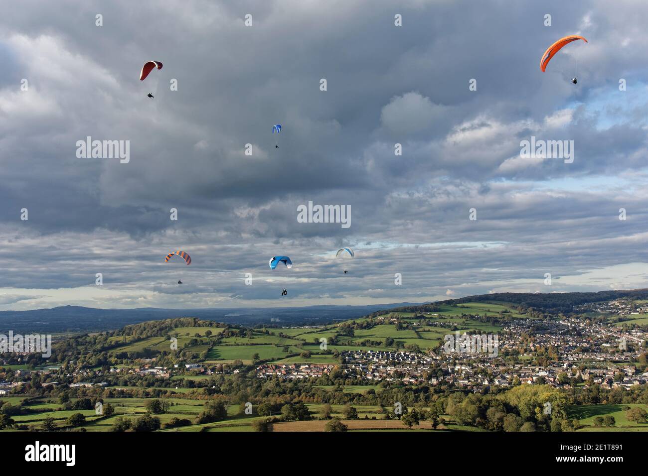 Parapendio volare da Selsley Hill, con Stroud e Gloucester sullo sfondo, Gloucestershire, Regno Unito, ottobre. Foto Stock