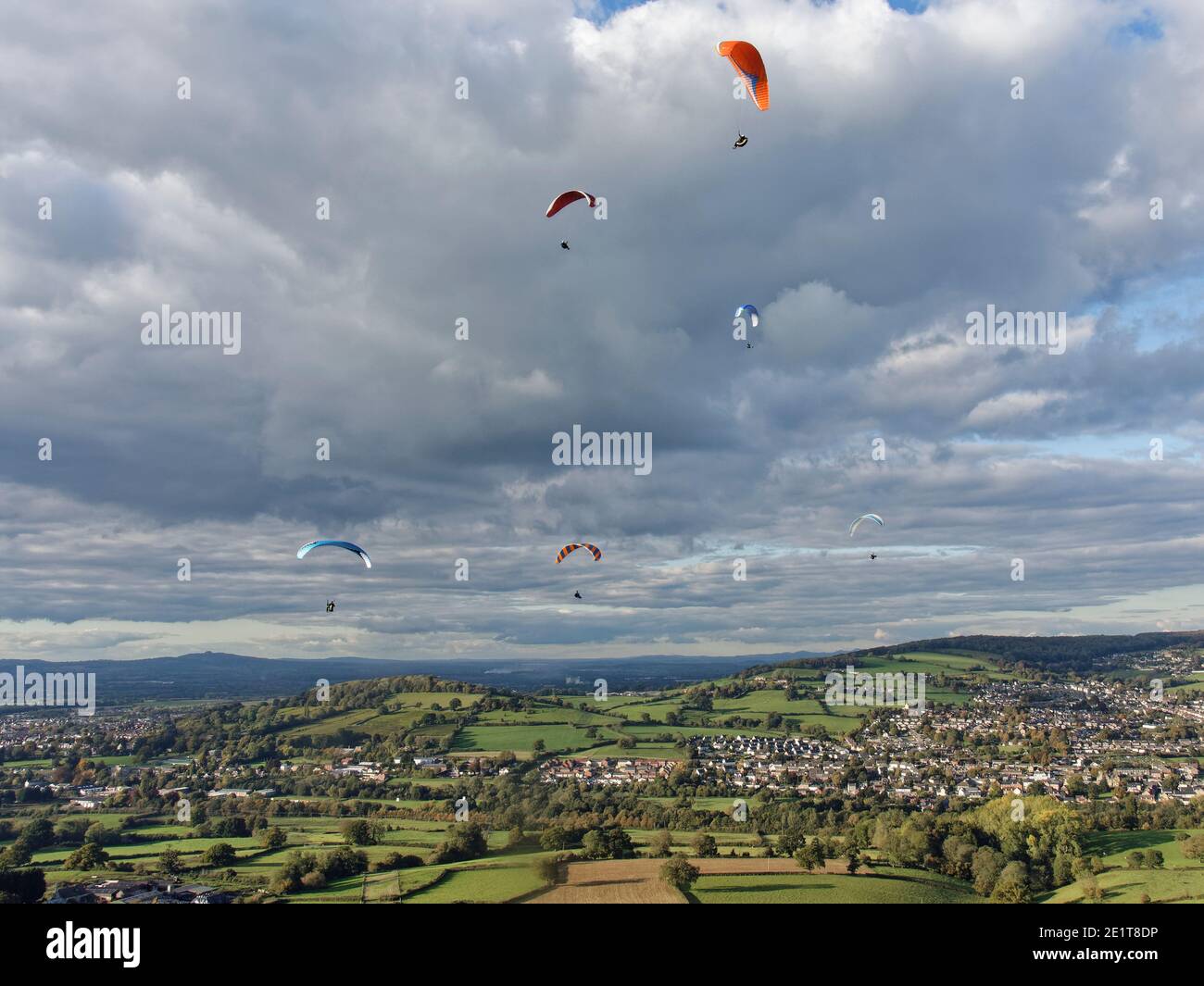 Parapendio volare da Selsley Hill, con Stroud e Gloucester sullo sfondo, Gloucestershire, Regno Unito, ottobre. Foto Stock