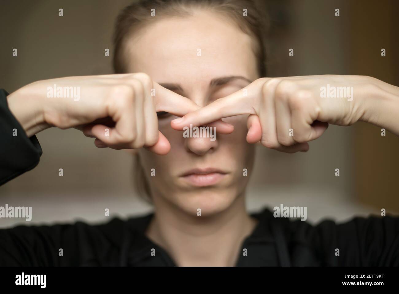Una giovane donna tocca il naso perché perde il suo senso di odore, non sente l'odore Foto Stock