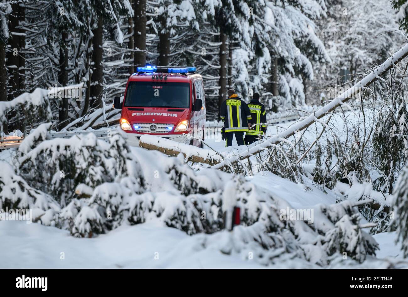 Schmitten, Germania. 09 gennaio 2021. Il dipartimento dei vigili del fuoco di Oberursel si trova tra alberi caduti sulla strada tedesca di Limes. La zona di Feldberg nel Taunus è chiusa a causa della rottura della neve e per evitare un assalto di escursionisti invernali. La cima è accessibile solo senza trasporto motorizzato. Credit: Andreas Arnold/dpa/Alamy Live News Foto Stock