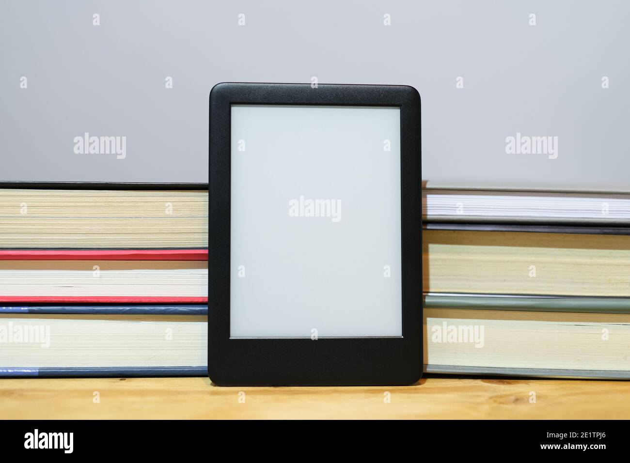 Lettore digitale di e-book con sfondo classico di libri cartacei, nuove tecnologie della conoscenza Foto Stock