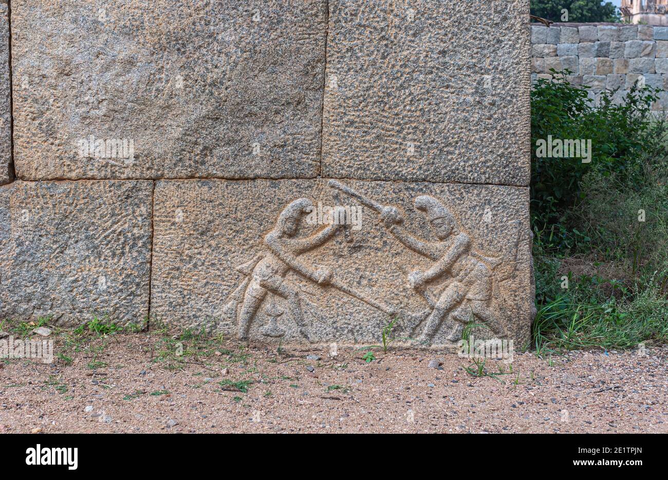 Hampi, Karnataka, India - 5 novembre 2013: Contenitore Zanana. Un grande edificio lineare in pietra marrone è stabile per gli elefanti sotto il cielo blu e l'erba verde Foto Stock