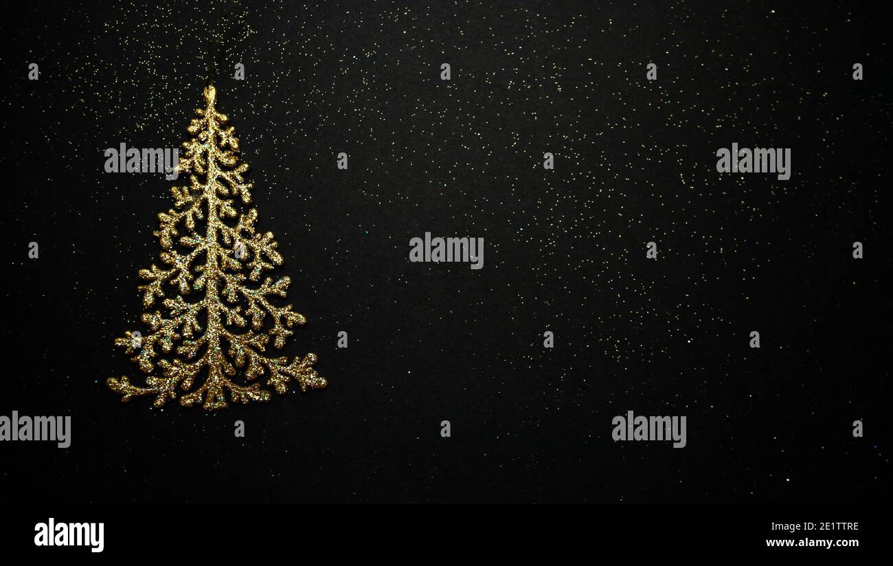 Albero di New Year su sfondo nero. Un regalo di Natale. Giocattolo d'oro per l'albero di Natale. Splendido sfondo per il tuo desktop. Foto Stock