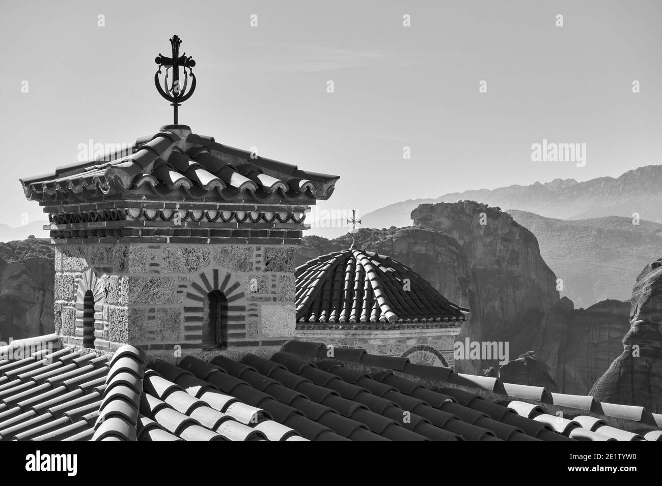 Cupole con croci del monastero ortodosso di Varlaam e rocce di Meteora sullo sfondo, Grecia. Paesaggio greco bianco e nero Foto Stock