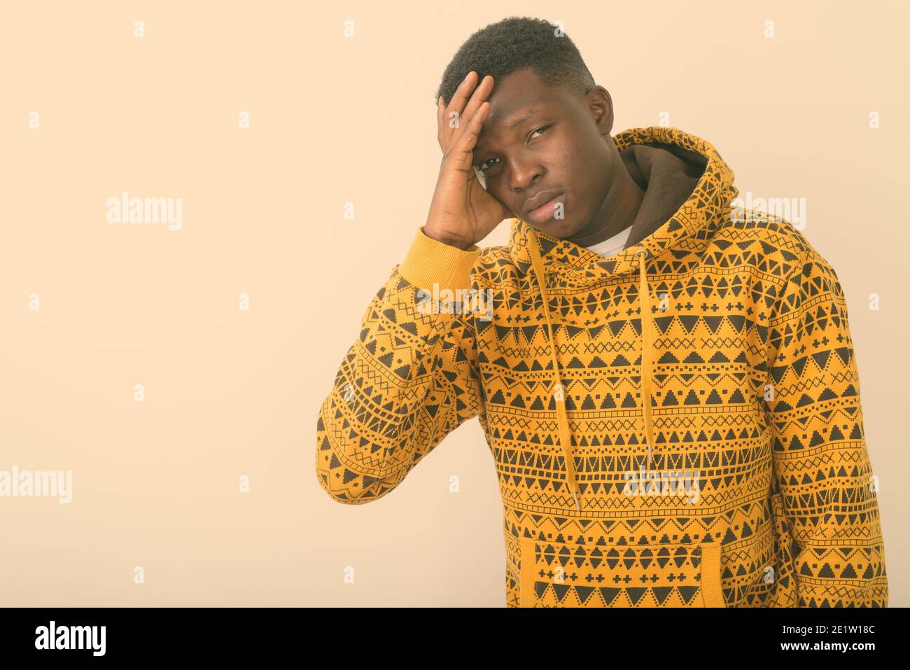 Studio shot del giovane nero africano avente mal di testa contro uno sfondo bianco Foto Stock