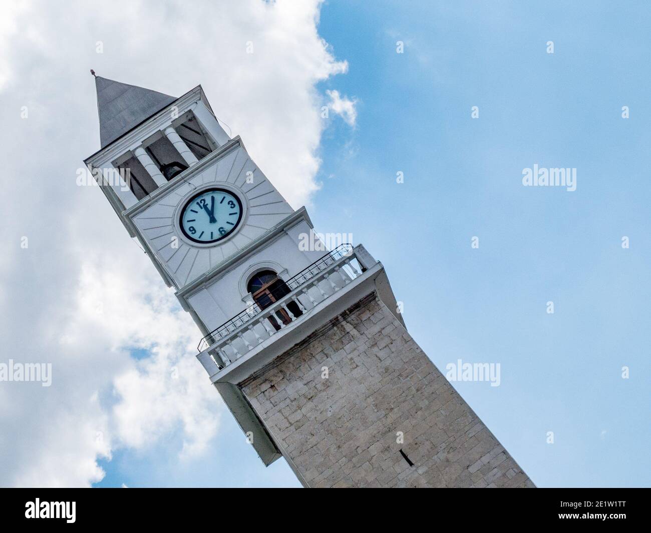 Torre dell'orologio bianca che mostra le 13:00 dal basso e ad un angolo. Tirana, Albania Foto Stock