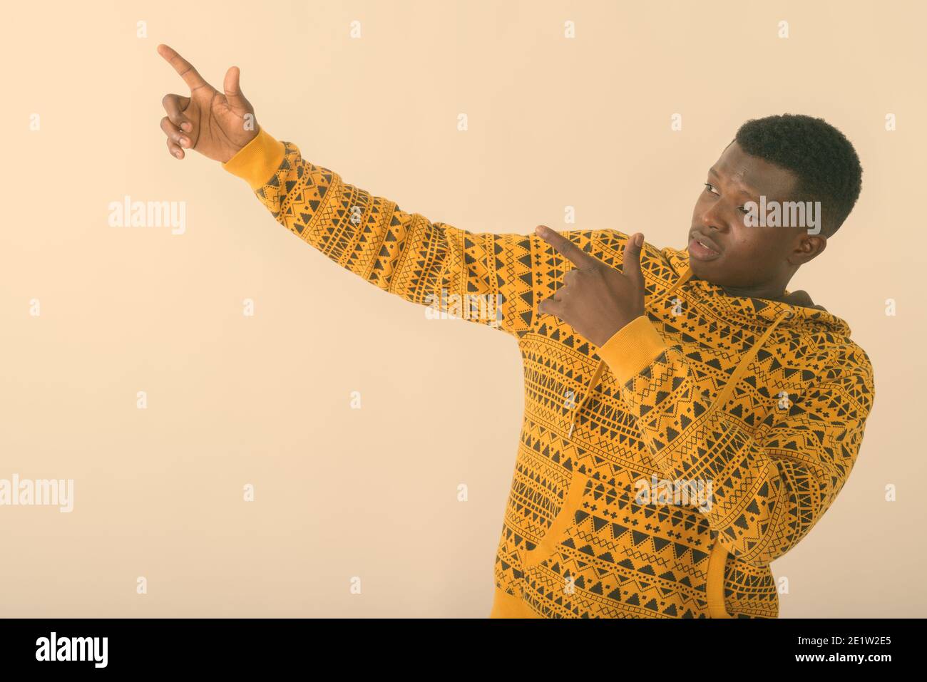 Studio shot del giovane nero africano puntando entrambe le dita in su contro uno sfondo bianco Foto Stock