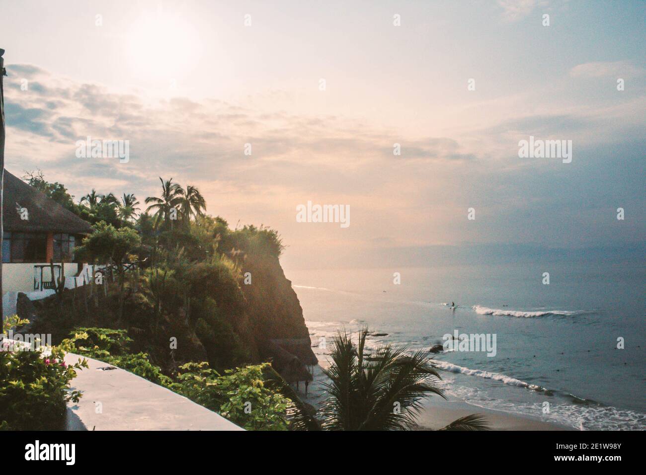 una costa dall'oceano pacifico con palme e molto altro alberi facendo surf nelle onde Foto Stock