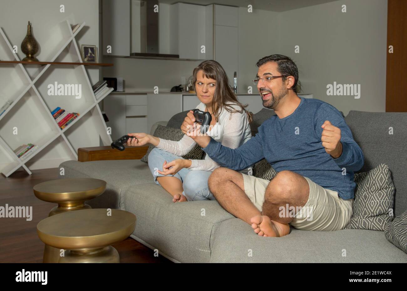 coppia che gioca ai videogiochi nel proprio appartamento in città Foto Stock