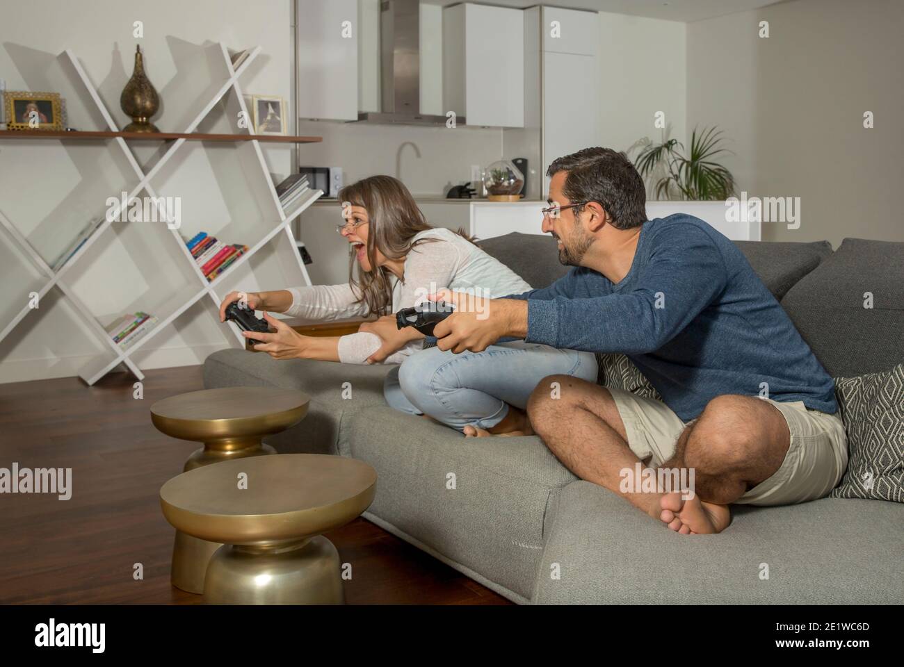 coppia che gioca ai videogiochi nel proprio appartamento in città Foto Stock