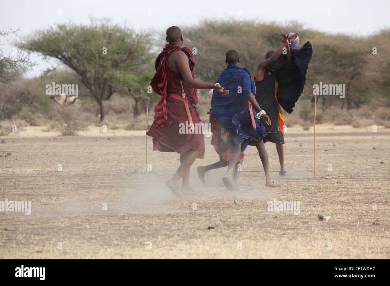 I giovani Masai Warriors giocano a calcio nella savana Foto Stock