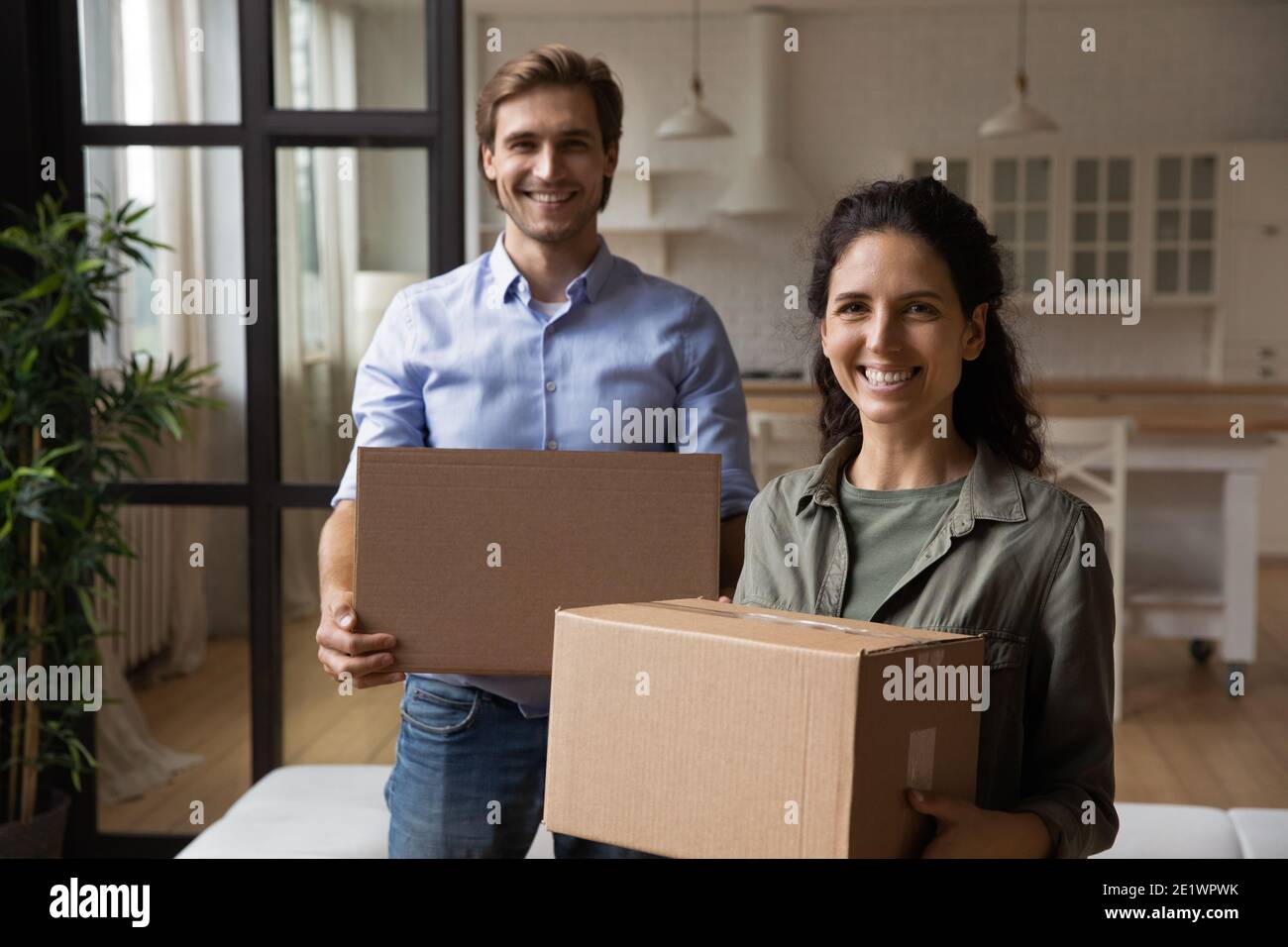 Ritratto di una coppia sorridente che si ricolloca nel nuovo appartamento Foto Stock