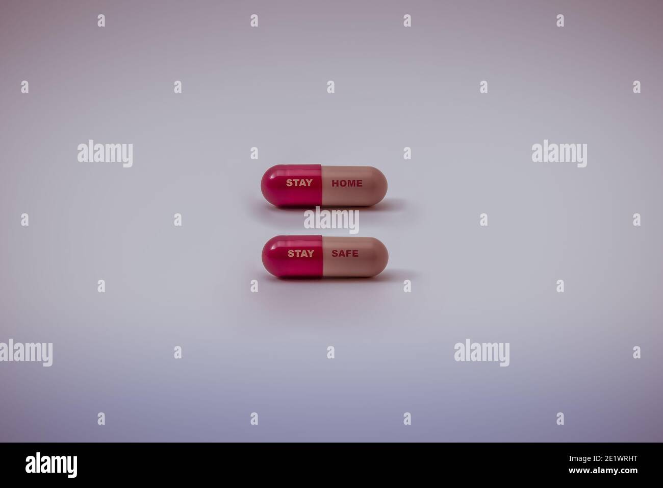 Colourful Covid 19 (Corona Virus / Sars- COV-2) pillole la lettura 'Stay home, Stay safe' isolato su sfondo bianco con copia spazio farmaco per preve Foto Stock