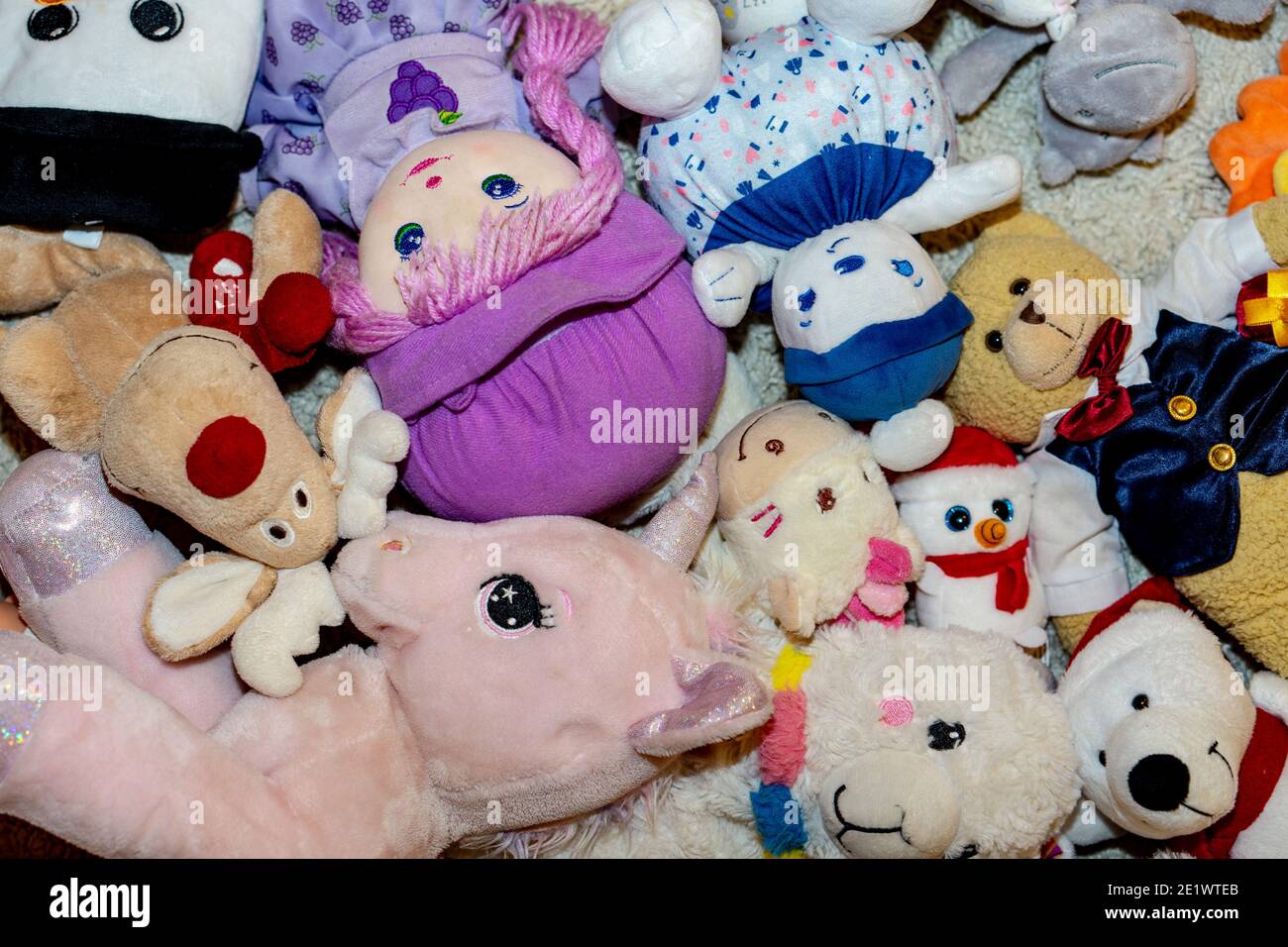 diversi tipi di peluche morbidi giocattoli sul pavimento ovunque in una camera per bambini Foto Stock