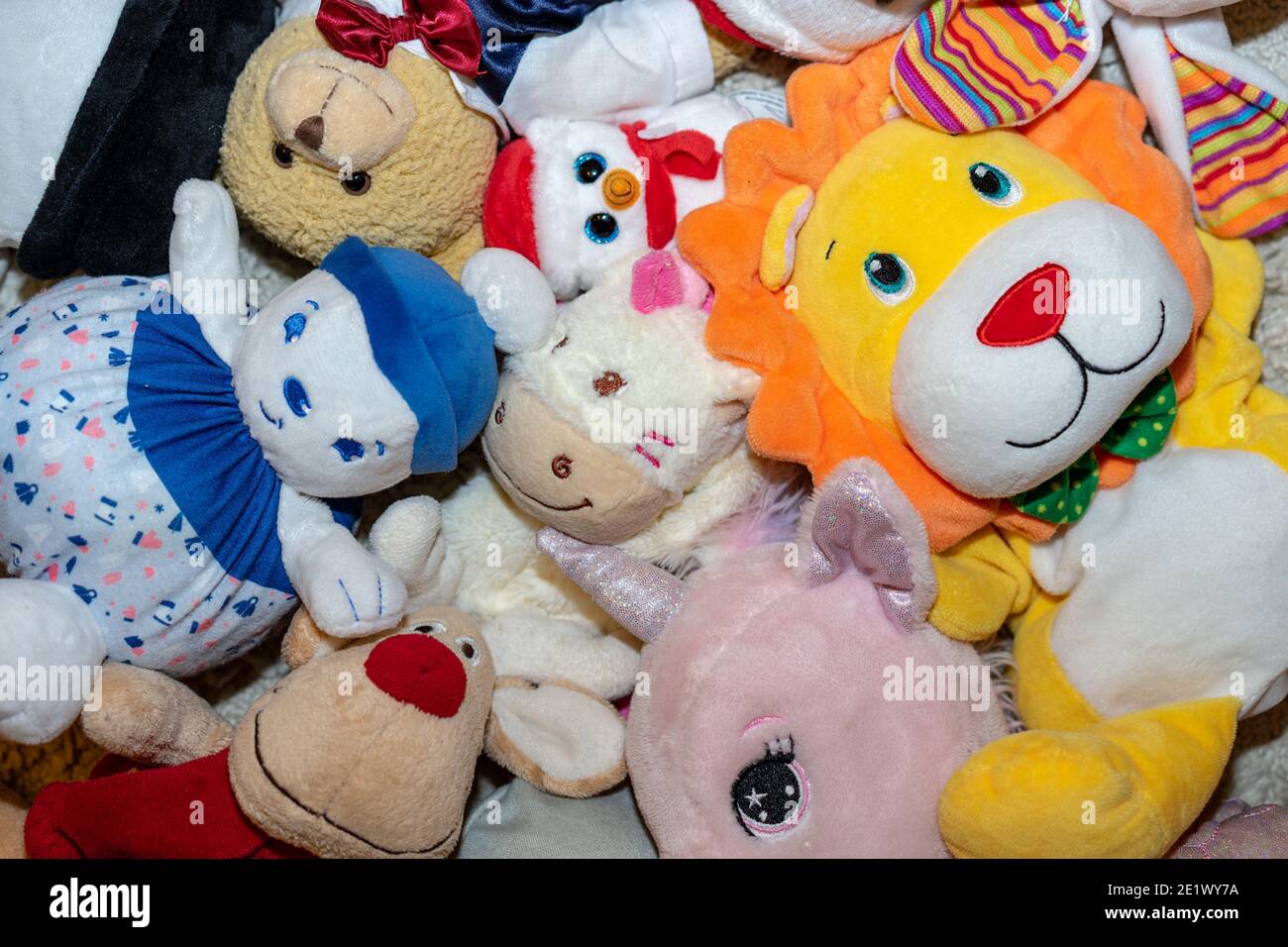 diversi tipi di peluche morbidi giocattoli sul pavimento ovunque in una camera per bambini Foto Stock