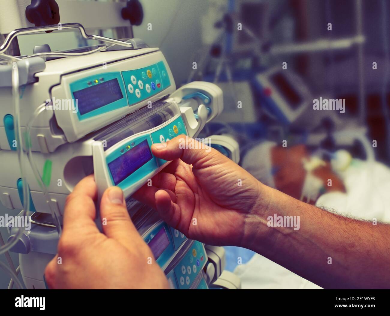 L'operatore medico configura l'apparecchiatura in ICU. Foto Stock
