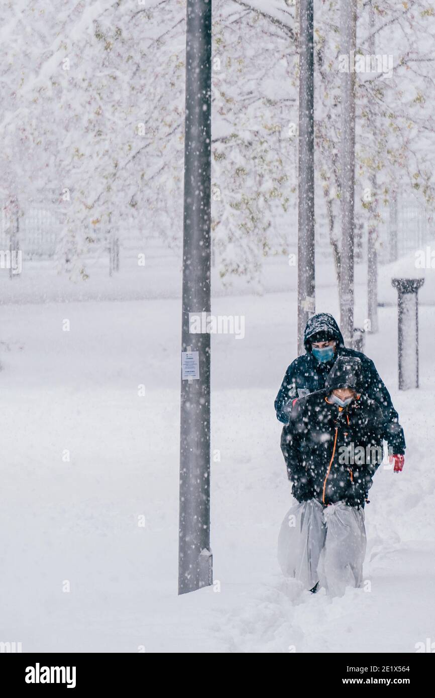 Madrid, Spagna - Gennaio 2021: Due persone che cercano di camminare su 30 cm di neve nella capitale della Spagna, dopo gli scioperi di Filomena Storm Foto Stock