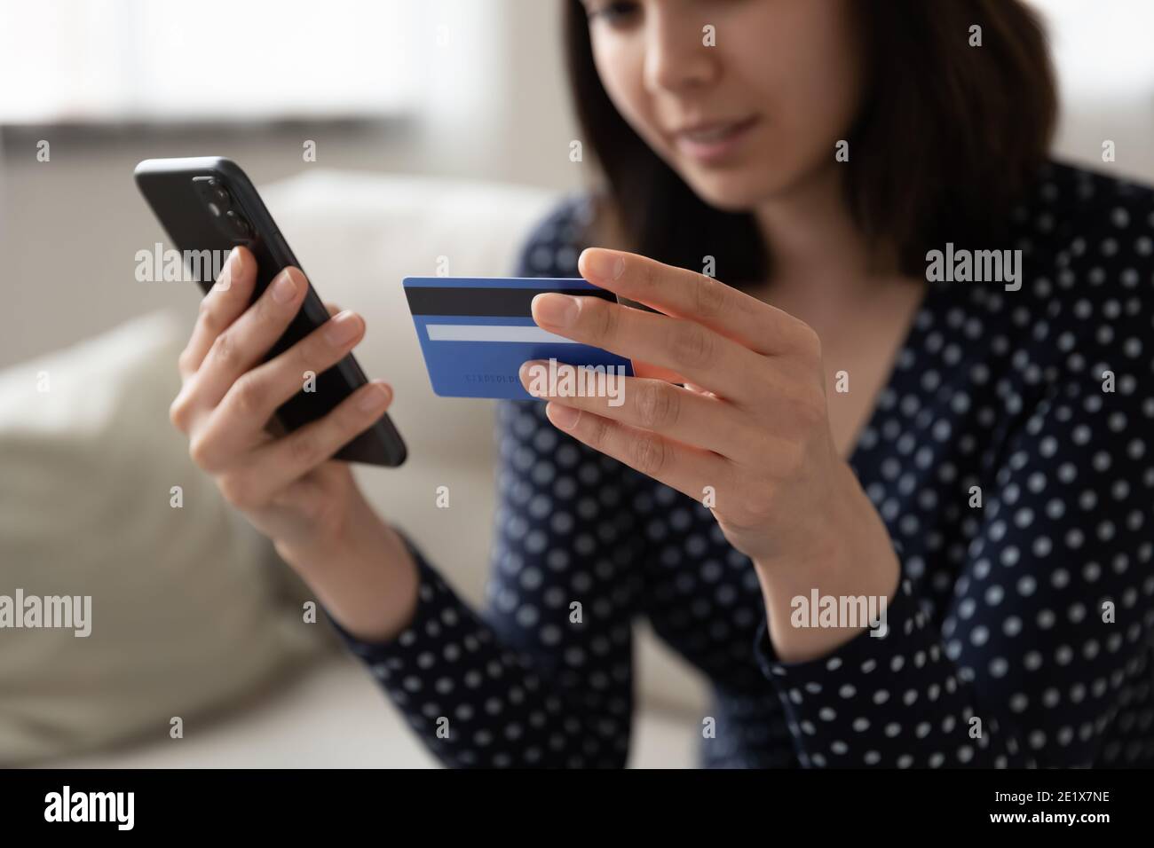 Primo piano su giovane cliente di razza mista femminile utilizzando l'applicazione e-banking, Foto Stock
