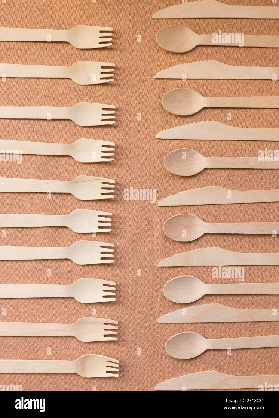 Due colonne di posate in legno. Quella sinistra ha dieci forcelle e quella destra coltelli e cucchiai. Foto Stock