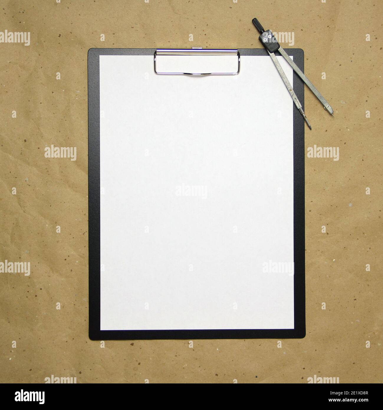 Una tavoletta con un foglio bianco di formato A4 con divisori su una carta da artigianato beige. Concetto di misurazioni, studi e costruzioni accurate. Foto a stock w Foto Stock