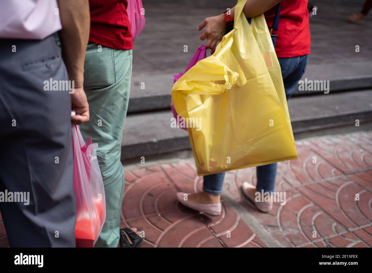 Per trasportare oggetti da un negozio sono state utilizzate coloratissime borse di plastica monouso. Foto Stock
